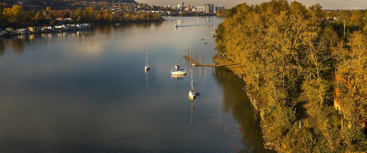 Recreation activity on the Willamette River in Milwaukie, Oregon. Portland cityscape on the background
