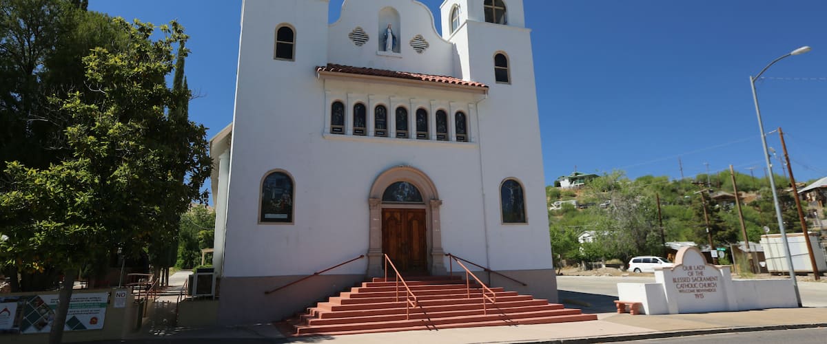 A white church with two towers and a wooden door.