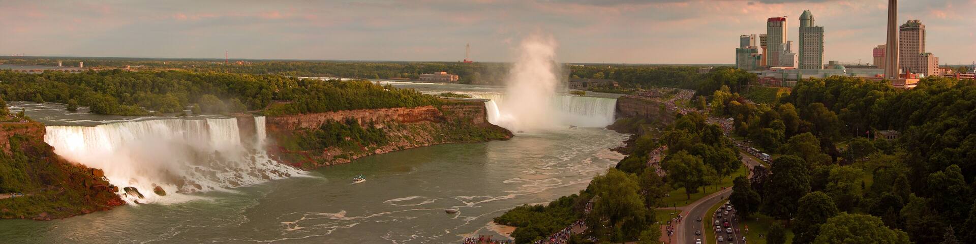 A large waterfall, a river, and a cityscape with tall buildings.