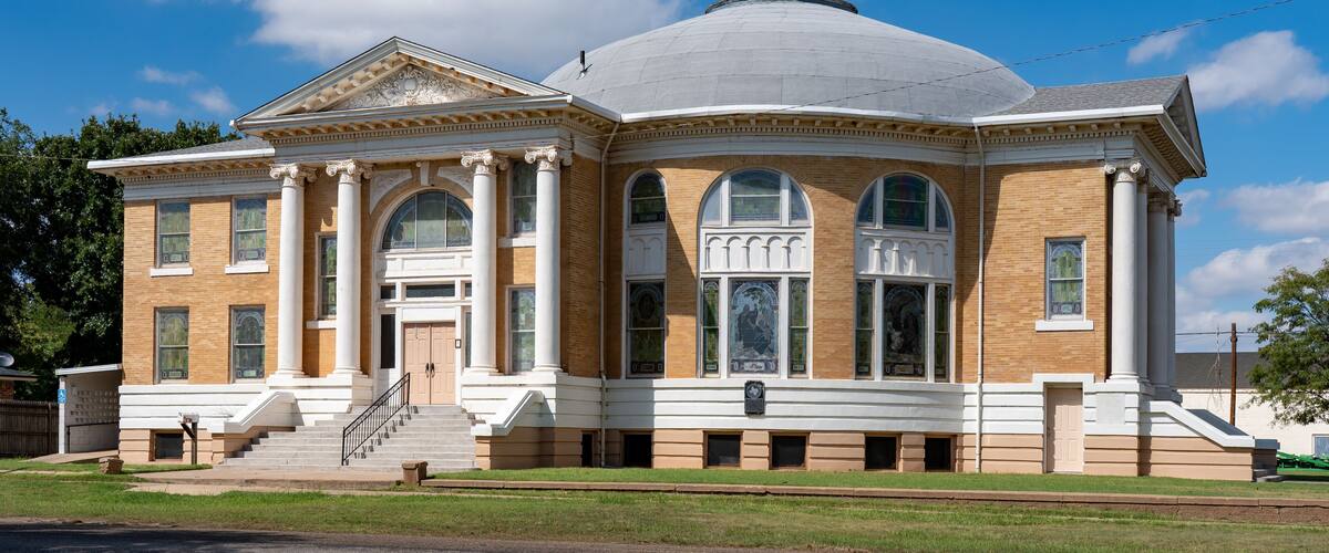 A historic building with a dome, columns, and arched windows.