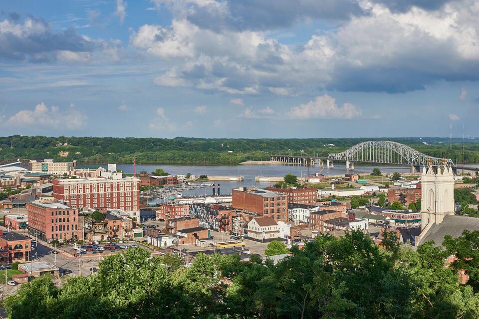 A cityscape with a prominent bridge, dense urban buildings, and a river.