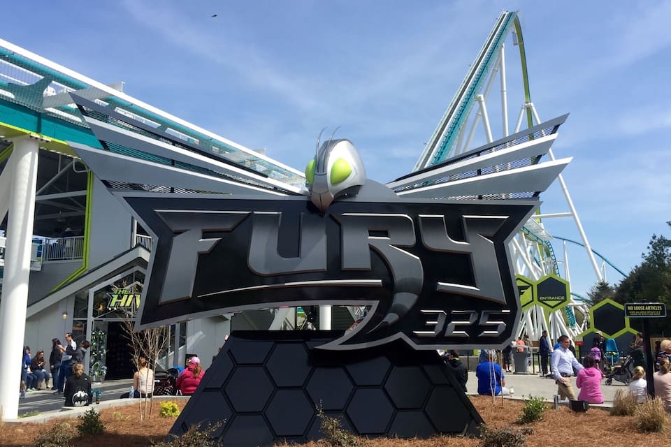 A large sign for 'Fury 325' with a roller coaster in the background.