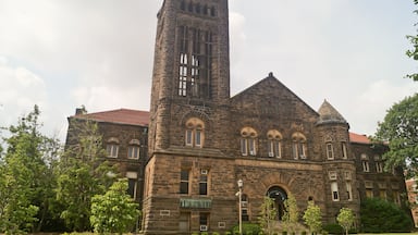 A historic stone building with a tall tower and arched windows.