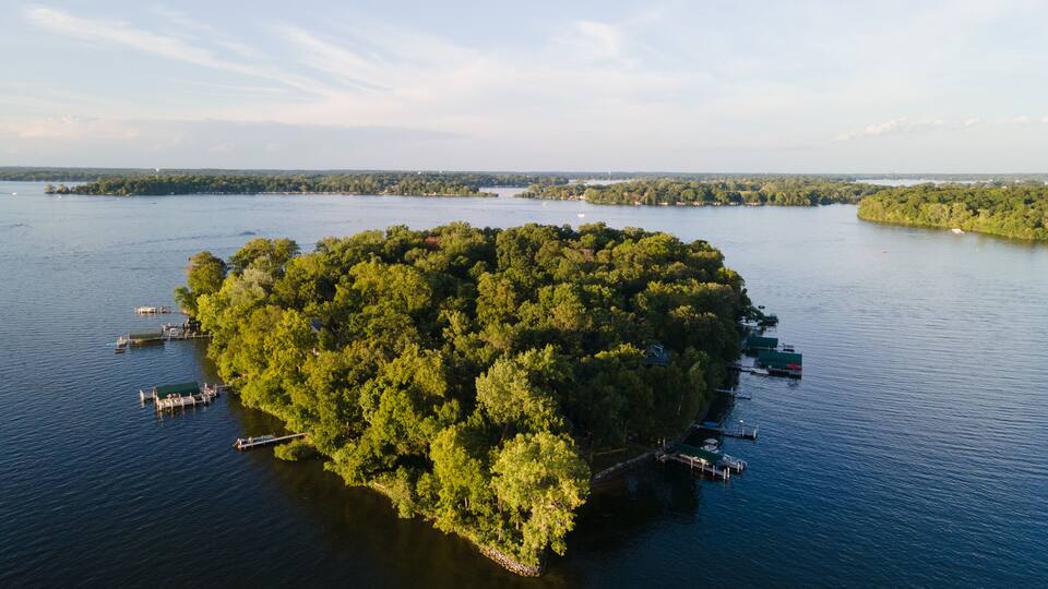 An island surrounded by water with docks and boats.