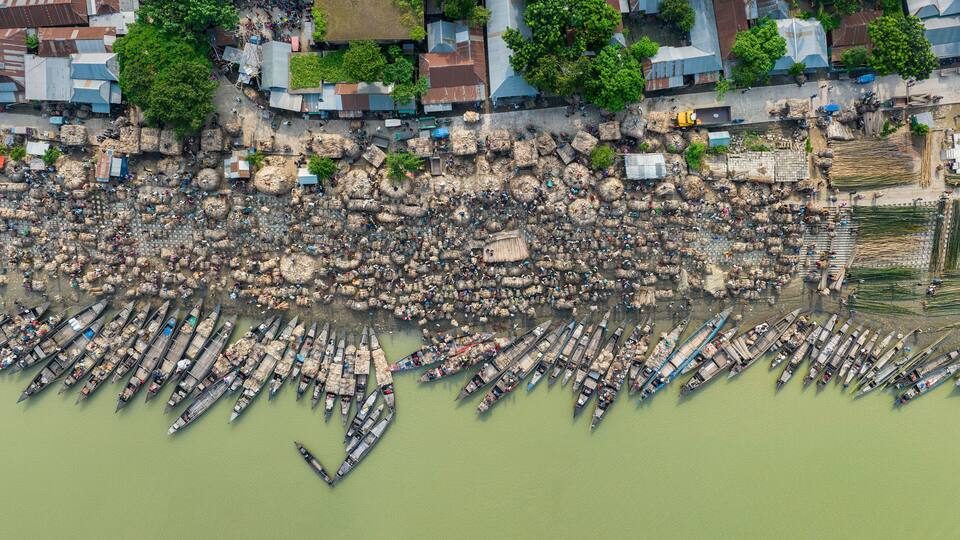 A densely packed riverside with numerous boats docked along the shore.