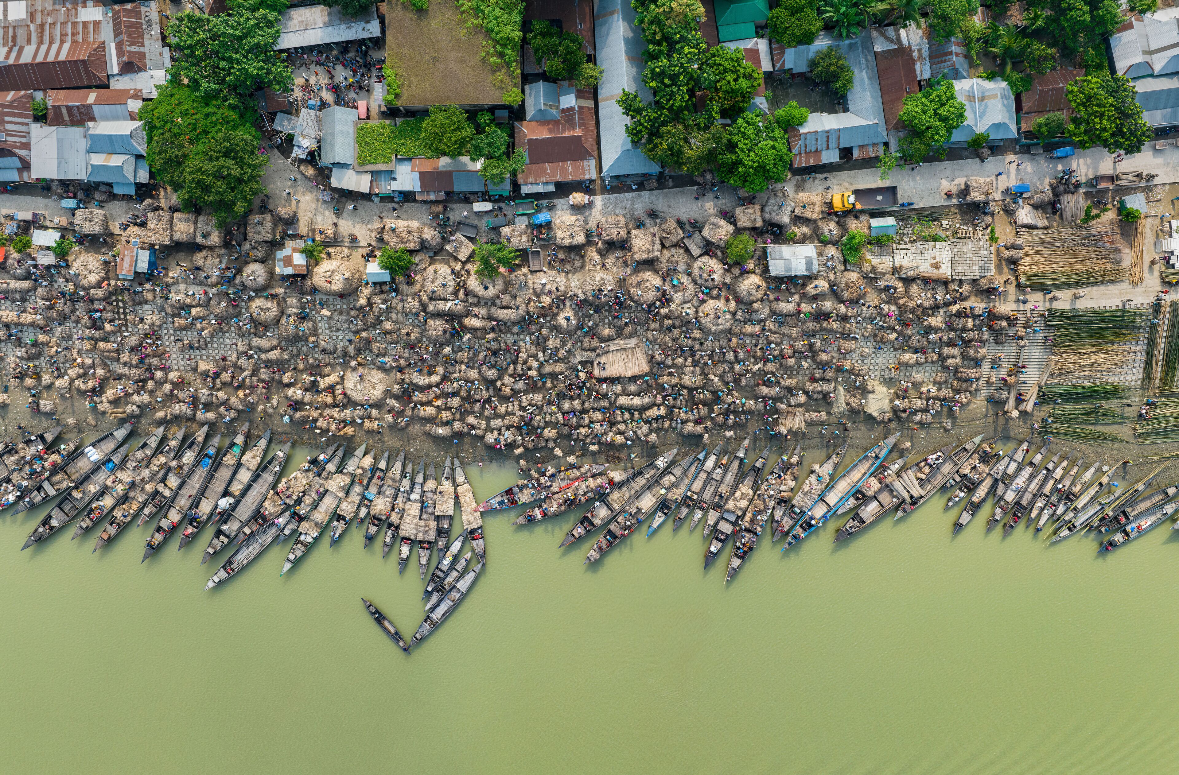 A densely packed riverside with numerous boats docked along the shore.