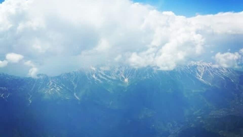 A mountain range with snow-capped peaks under a clear blue sky.