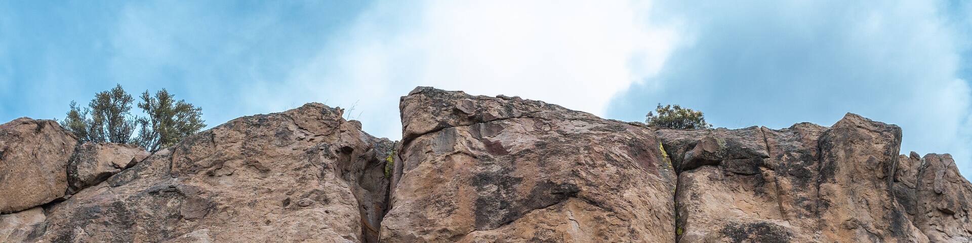A rocky cliff with a metal structure at its base.