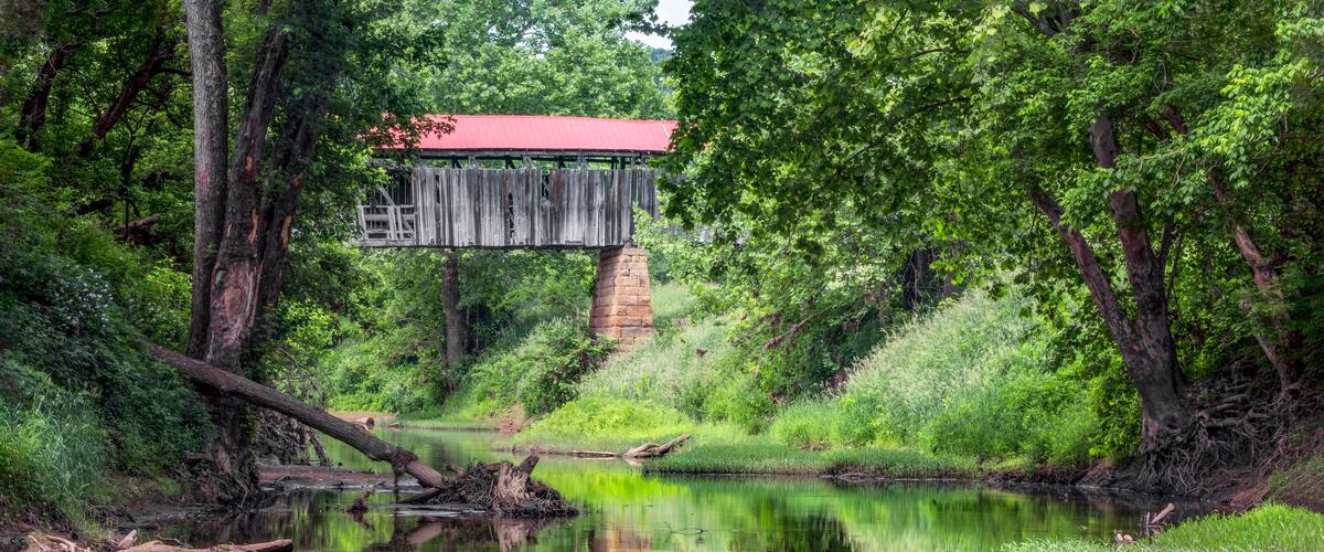 Historic Knowlton Covered Bridge is seen reflected in the waters of the Little Muskingom River in rural Monroe County, Ohio. This old bridge collapsed in the summer of 2019.