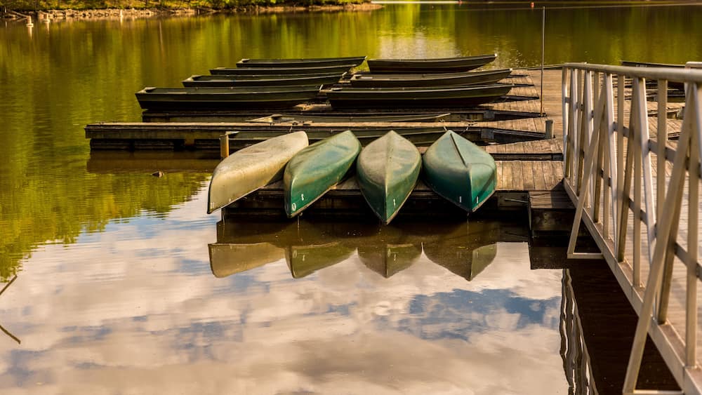 Canoes upside down on a dock on a lake