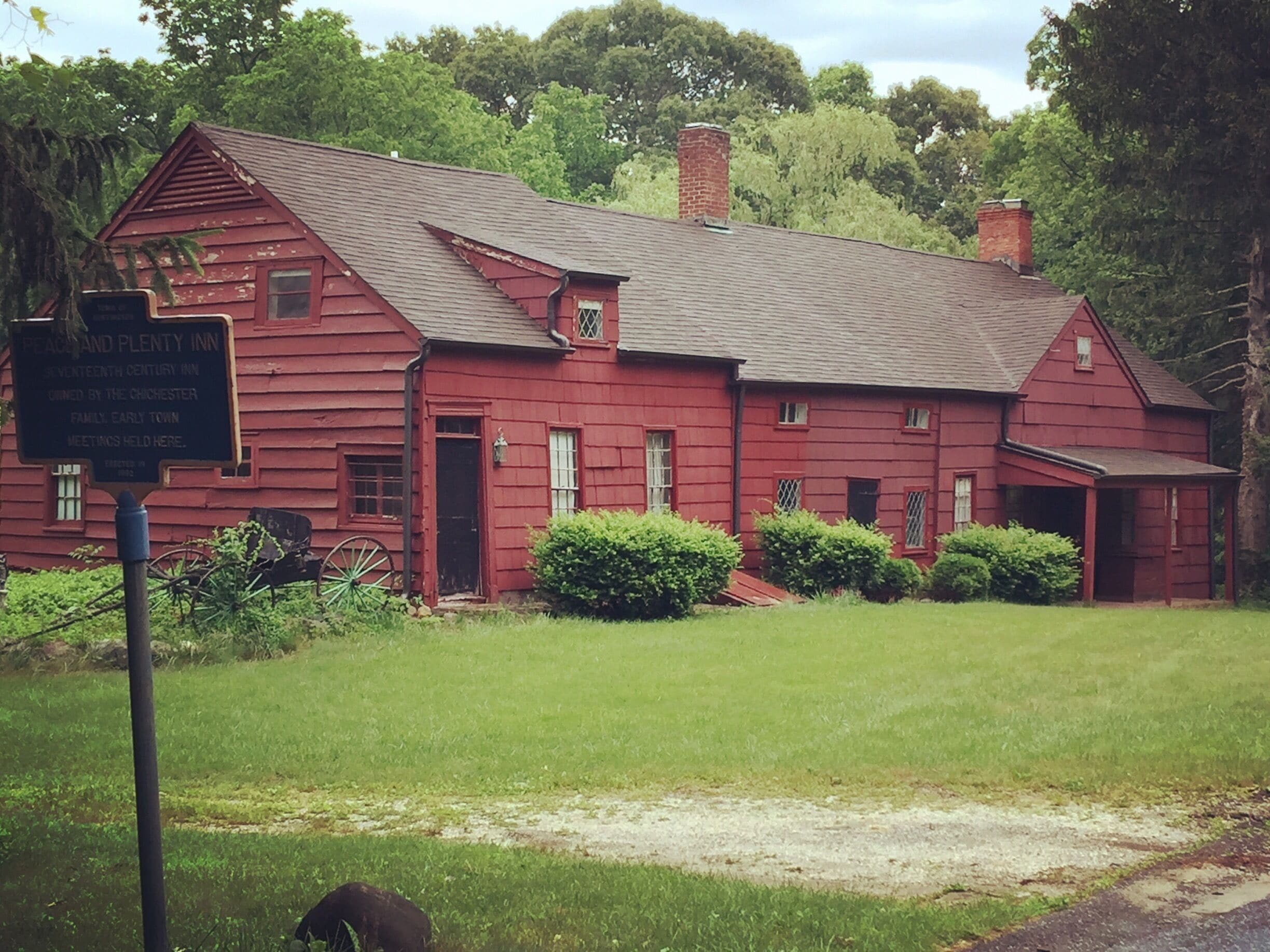 A red wooden building with a sign indicating it is the Peachland and Plenty Inn, a 19th-century inn.