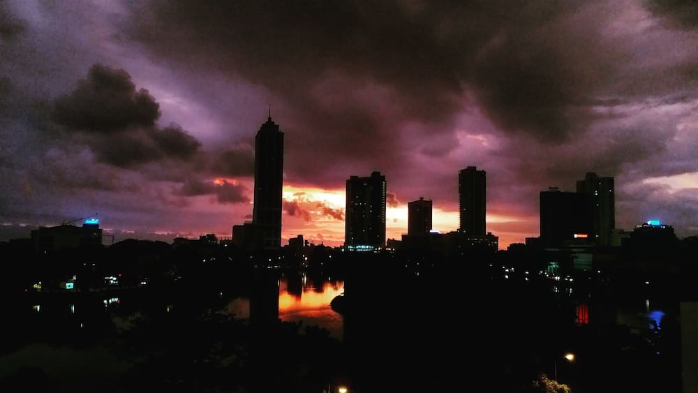 A city skyline at dusk with a dramatic sky.