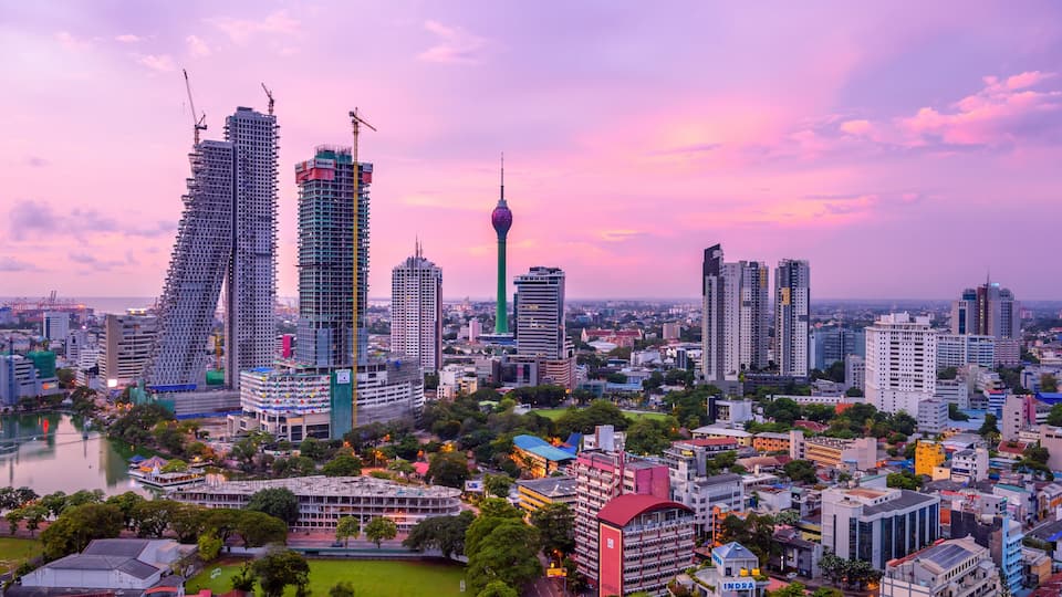A cityscape with a prominent tower, a river, and surrounding greenery.