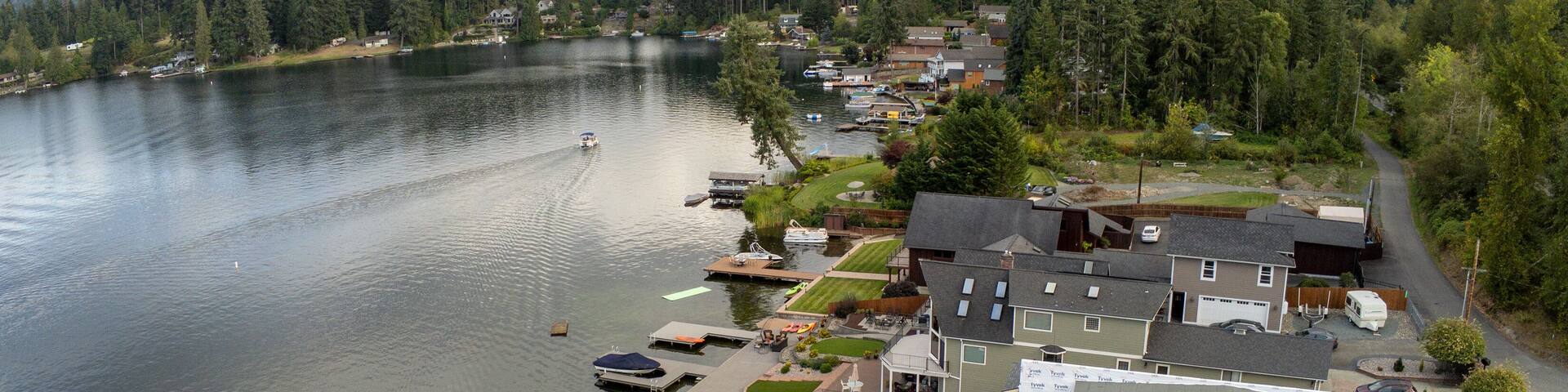 A lakeside residential area with houses, docks, boats, and a playground.