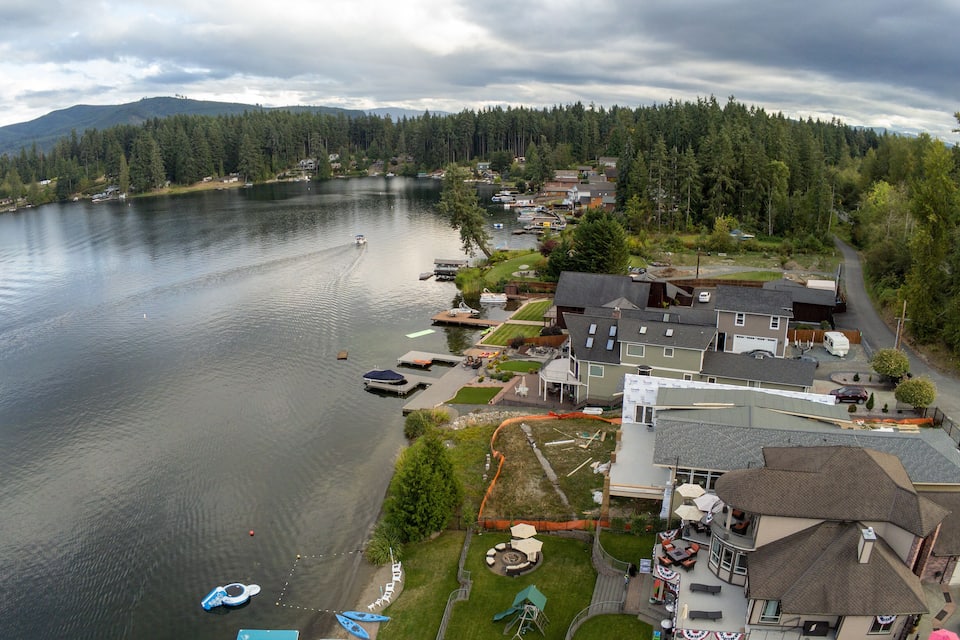 A lakeside residential area with houses, docks, boats, and a playground.