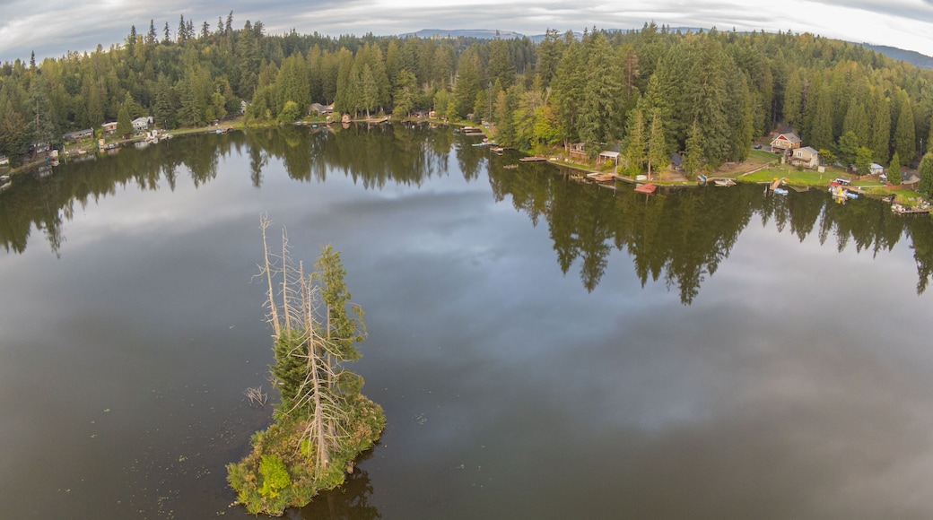 Picturesque Lake Whitman and a unique island with a tree house in the middle of the lake with stunning reflections of the forest in the water.