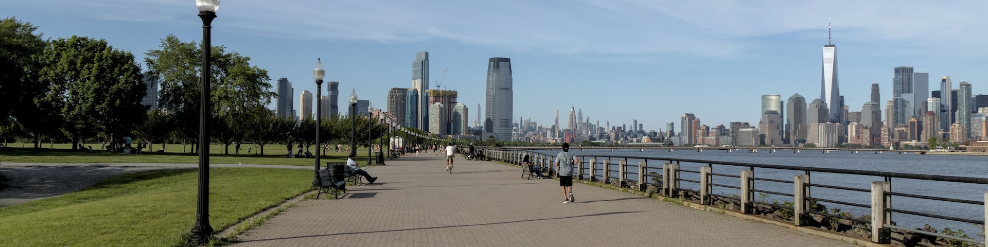 View of pedestrian walkway in Liberty State Park, Jersey City, NJ with view of downtown Manhattan New York City skyline.