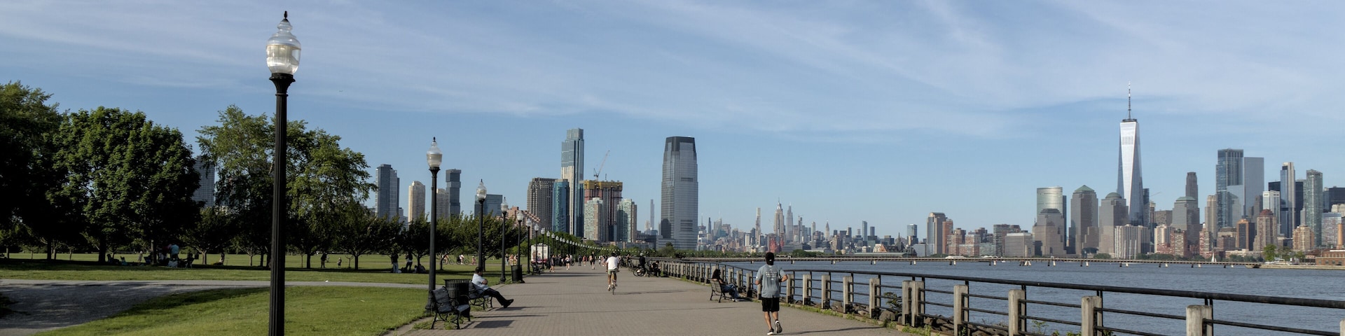 View of pedestrian walkway in Liberty State Park, Jersey City, NJ with view of downtown Manhattan New York City skyline.