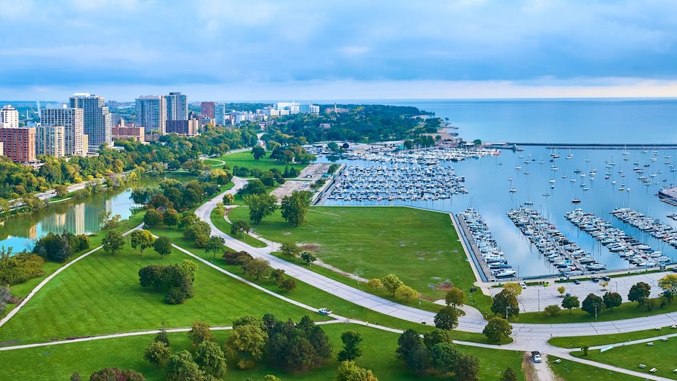 A cityscape with a marina, a lake, and surrounding greenery.