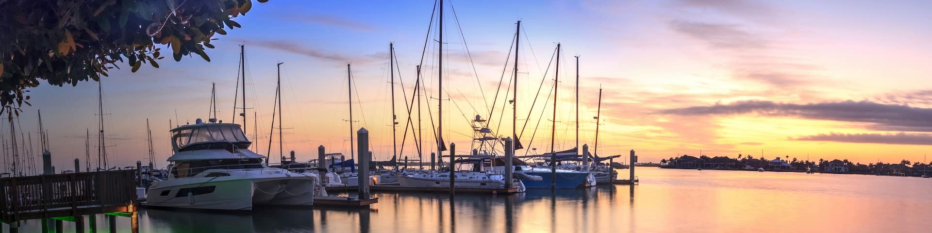Break of dawn sunrise over boats and sailboats at Factory Bay marina in Marco Island