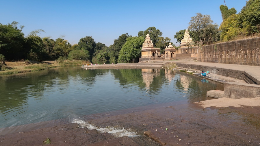 A calm river with a temple and steps leading to it.