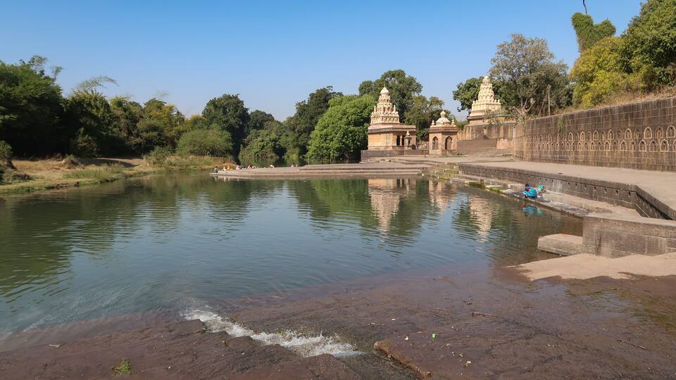 A calm river with a temple and steps leading to it.