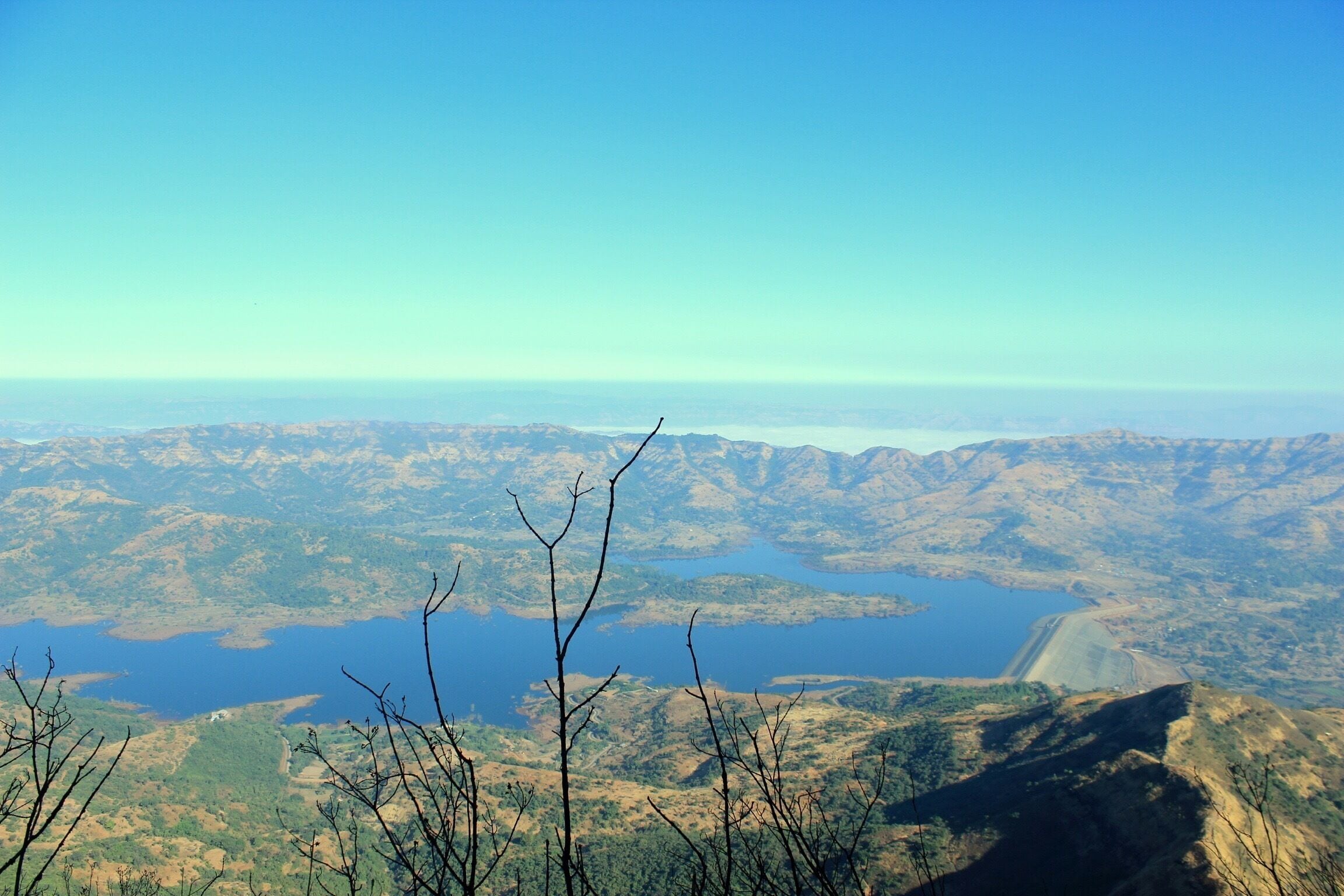 A mountainous landscape with a large lake and a dam.