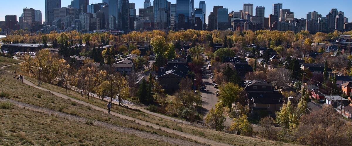 Stunning panoramic view of the skyline of Calgary, Alberta, Canada viewed from Crescent Heights in autumn season with colorful trees.