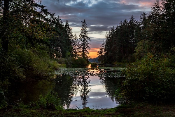 Beautiful dramatic sky and sunset reflection in calm water of The Lacamas Lake in Washington State