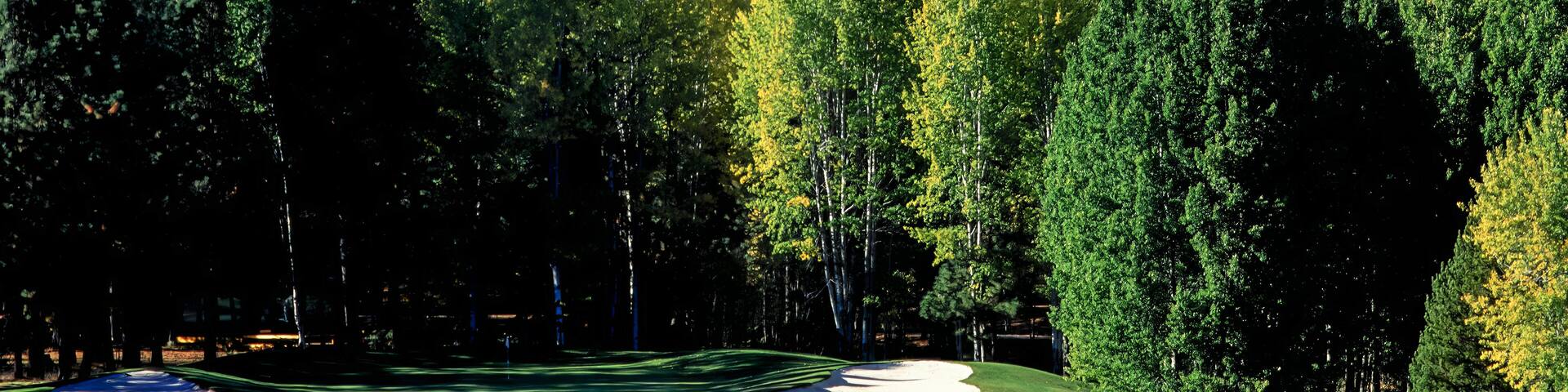 A golf course with a mountain backdrop.