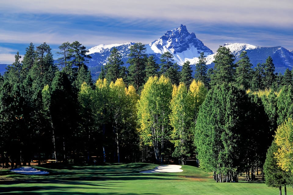 A golf course with a mountain backdrop.