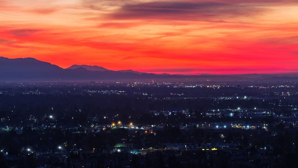 Colorful predawn view of San Fernando Valley neighborhoods and the San Gabriel Mountains in the city of Los Angeles, California.