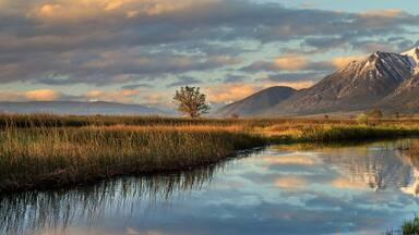 Carson Valley Sunrise in Genoa, Nevada with a reflection of a snow capped mountain called Job's Peak and a moody cloudy sky