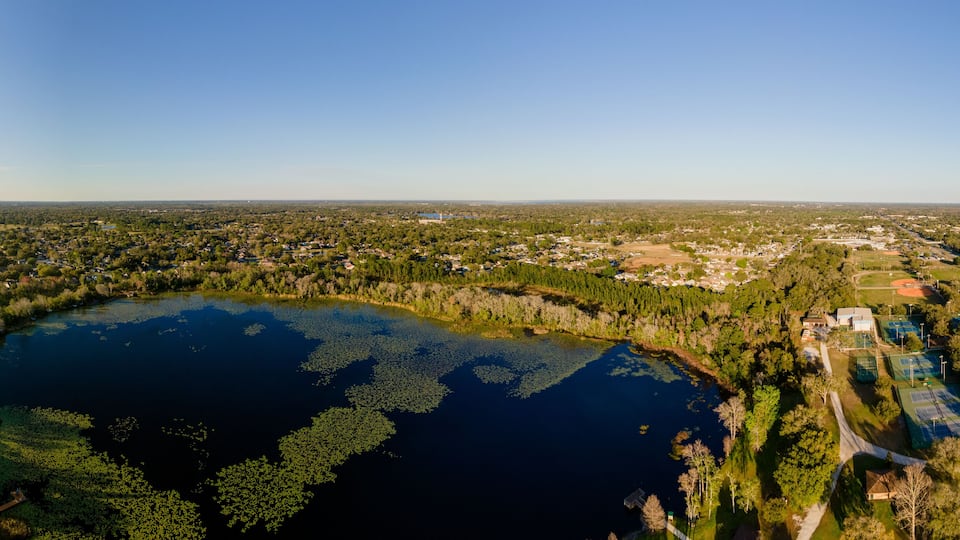 An aerial view of a lake surrounded by residential areas and greenery.