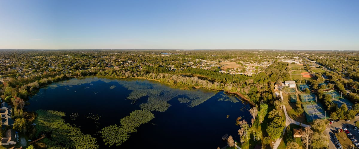 An aerial view of a lake surrounded by residential areas and greenery.