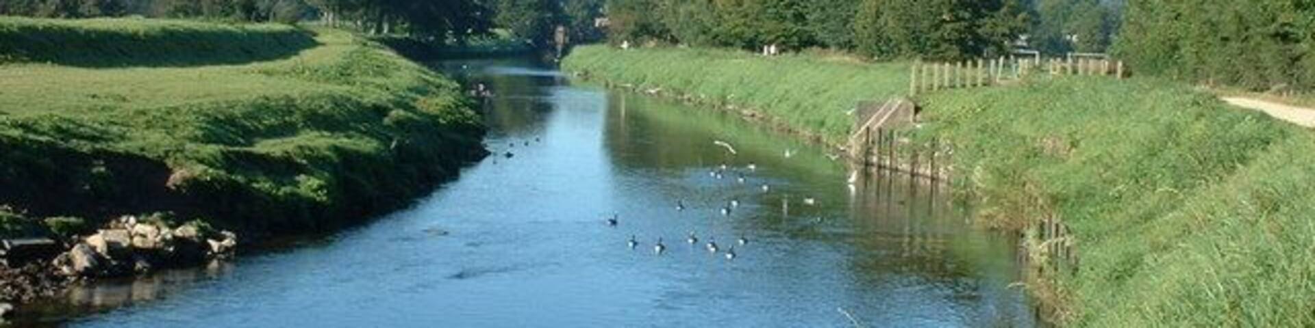 River Mersey near Parrs Wood This man made section of the River Mersey is constricted between levees to stop the annual flooding on this floodplain.