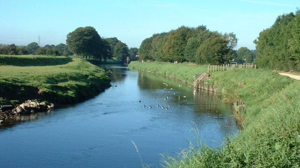 River Mersey near Parrs Wood This man made section of the River Mersey is constricted between levees to stop the annual flooding on this floodplain.