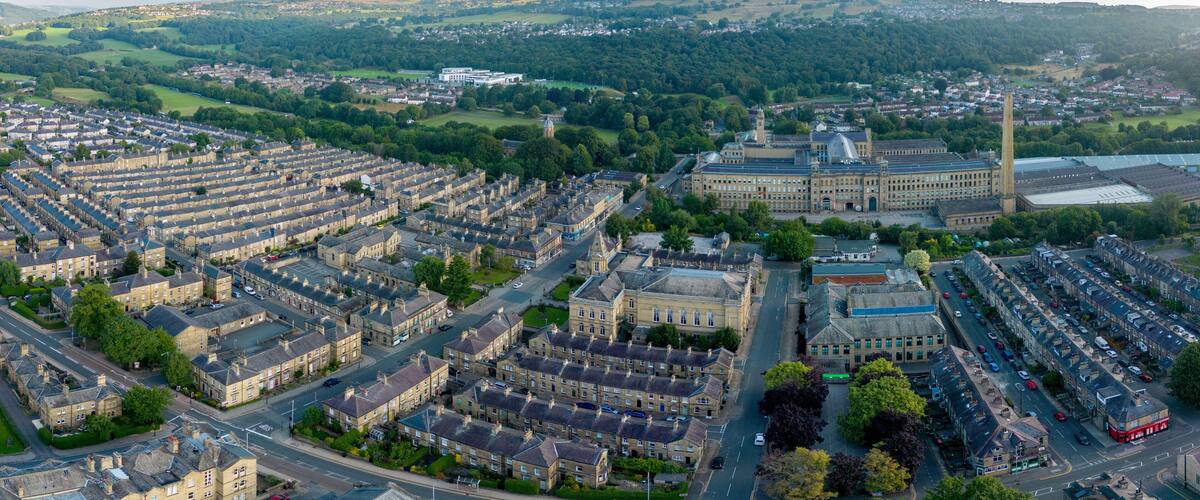 An aerial drone shot of Saltaire,the Victorian era Salt's Mill and associated residential district located by the River Aire and Leeds and Liverpool Canal is a designated UNESCO World Heritage Site an
