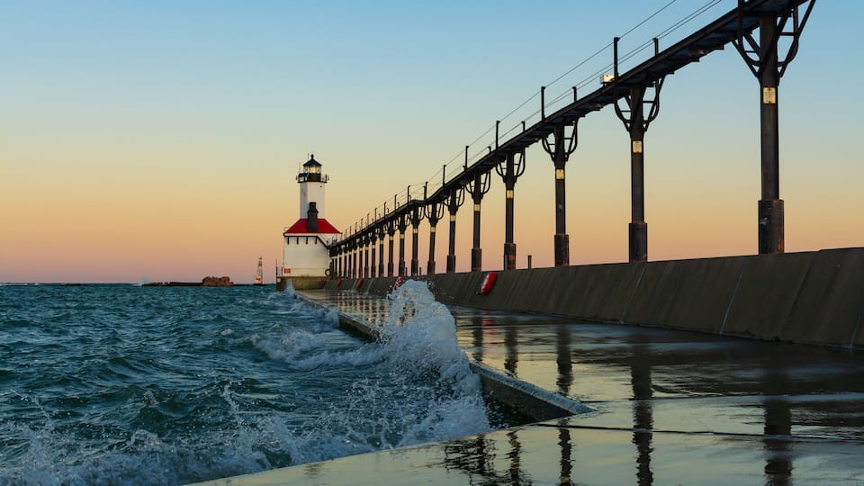 A pier extending into the water with a lighthouse at the end.