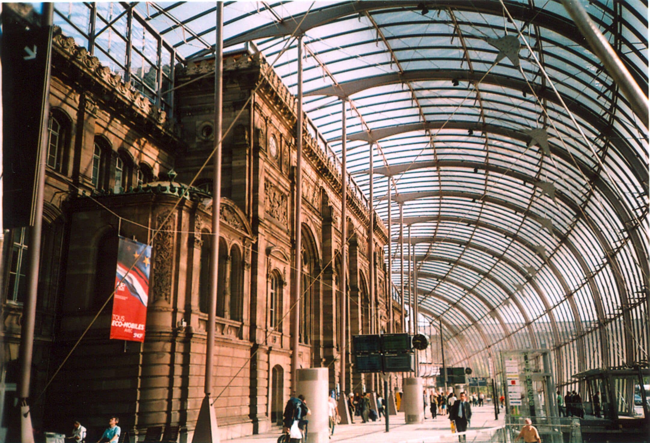 A historic building with a glass roof and people walking inside.