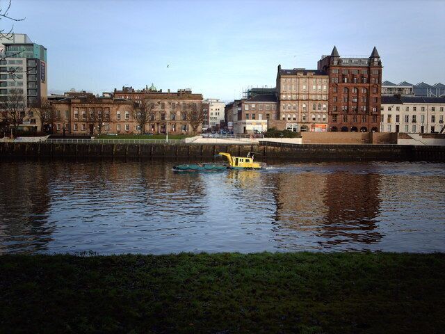 Customhouse Quay, Glasgow. Viewed from the south bank of the Clyde at Carlton Place, between Jamaica Bridge and the Suspension Bridge. The unusual craft is for picking up rubbish from the river.