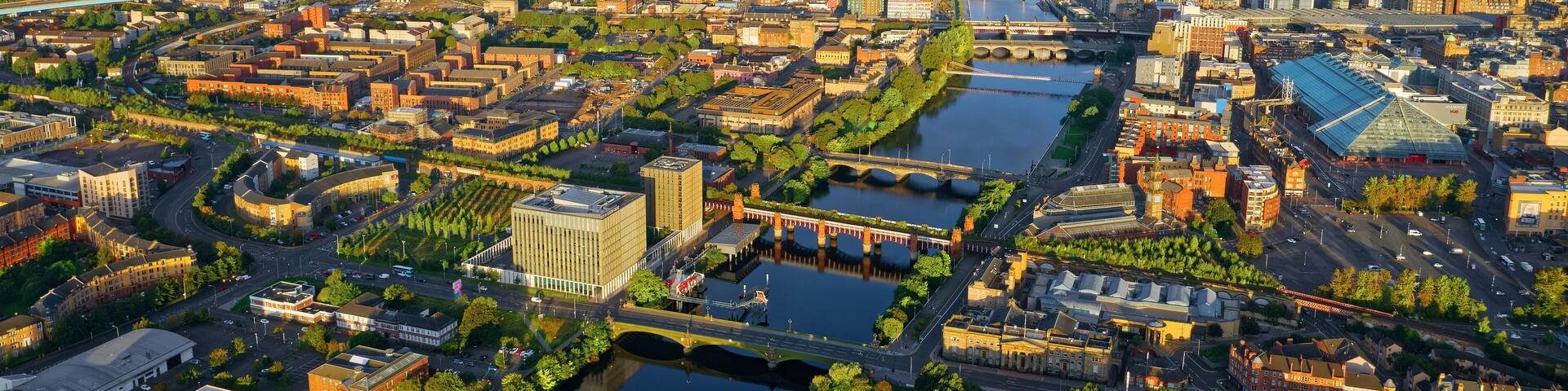 An aerial view of a city with a river, bridges, and various buildings.