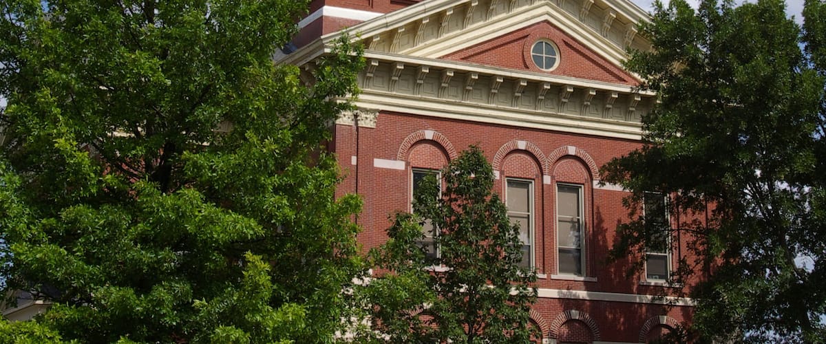 A large red brick building with a clock tower and a dome.