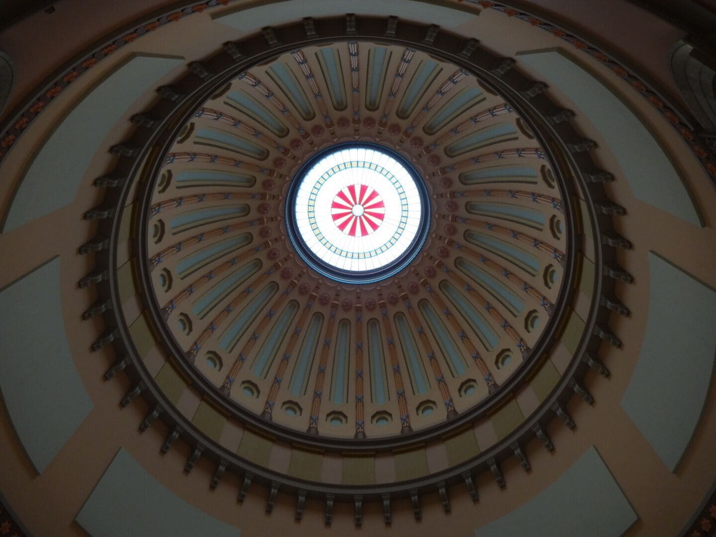 The Rotunda is one of the most remarkable spaces in the Statehouse. Stretching 120 feet from the floor to the oculus.

The crown jewel in the Rotunda's dome is its 29-foot-wide skylight. The center circle of the skylight is a hand-painted Great Seal of Ohio, a reproduction of the Seal that was in use in 1861 when the Rotunda was completed.

The seal in the dome, which is 3ft in diameter, is slightly different than the seal in use today. This seal not only has the mountains, a sheaf of wheat and a bundle of arrows, but it also includes a canal boat in the foreground. The canals were an important mode of transportation at the time this seal was designed (circa 1847). The seal has changed five times in the course of Ohio's history. 

#architecture