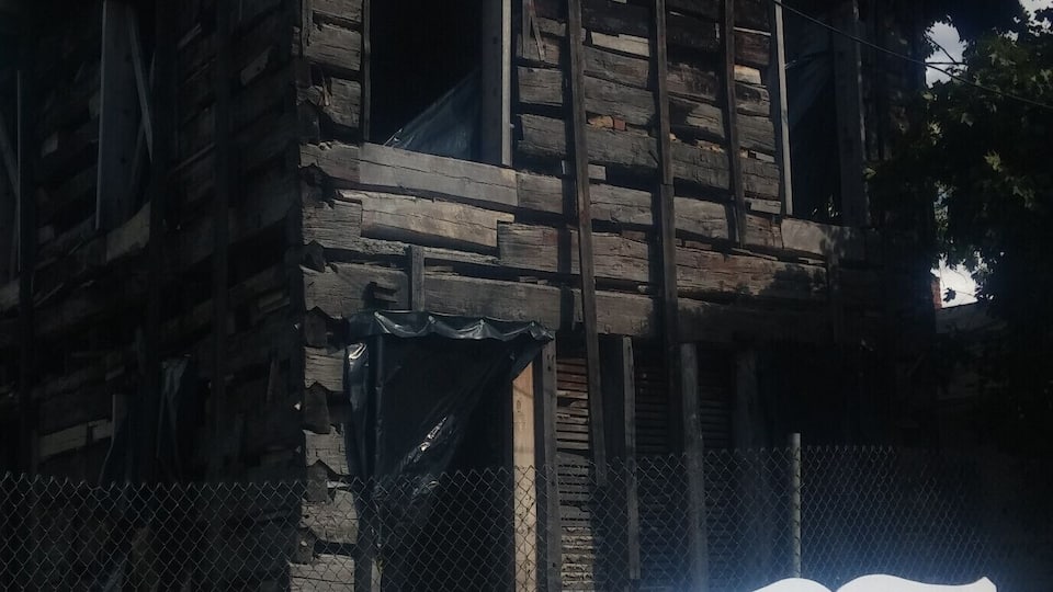 A historic log post office building, 1807 Franklinton, in a state of disrepair.