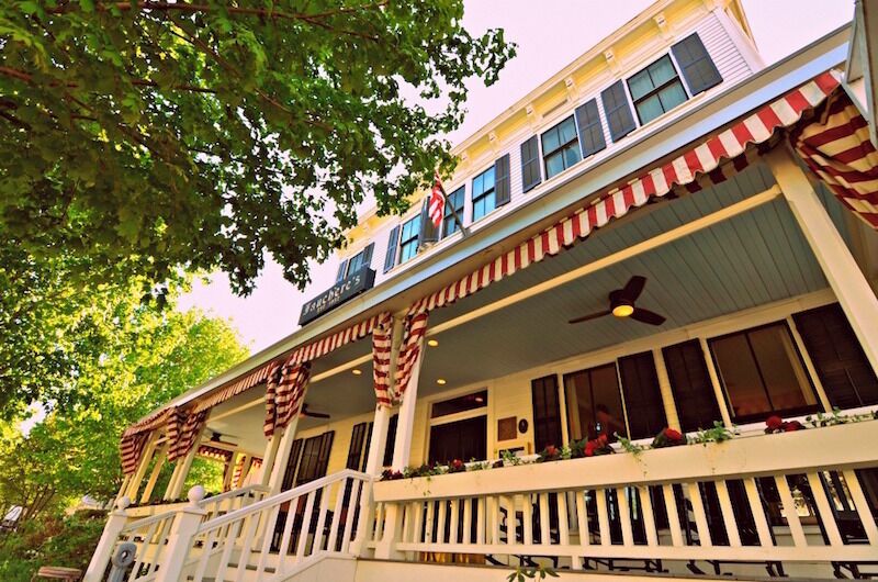 A building with a red and white striped awning, a balcony with railings, and a sign that reads "FARMERS MARKET".