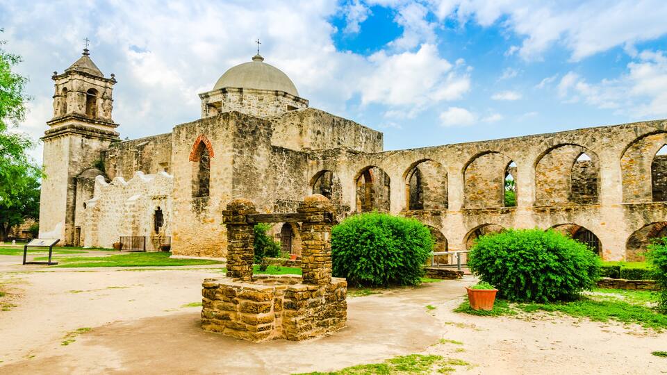 An old stone church with a bell tower and arches.