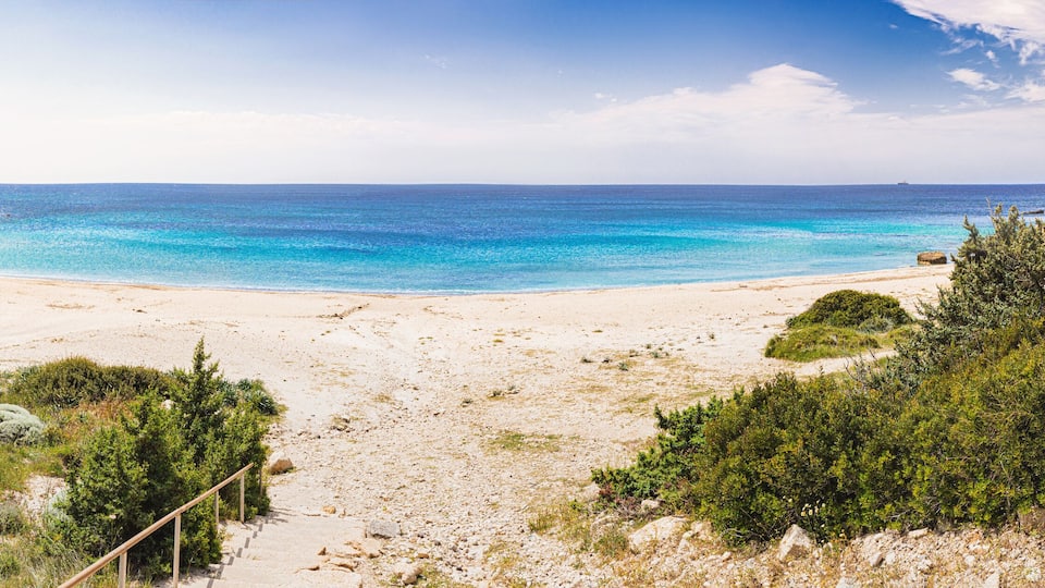 Panoramic view of Cleopatra cove beach with turquoise water and green vegetation in Cesme, Turkey
