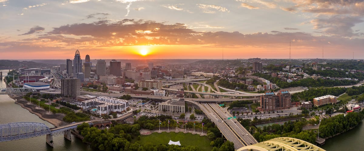 A cityscape of a city with a river, bridges, and a sunset.