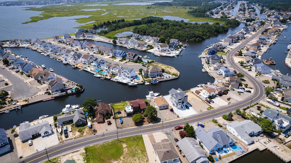 A coastal residential area with houses, docks, and a marina.